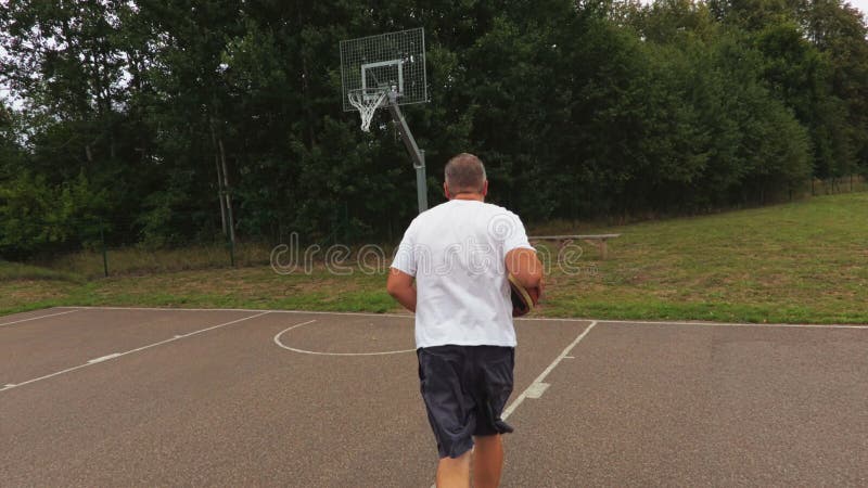 Kameran följer basketspelaren som försöker att kasta i korg lager videofilmer