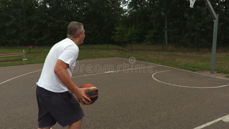 Kameran följer mannen med basketbollen stock video
