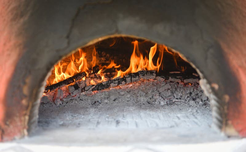 Kamin mit Lehm-Ofenfeuer des Klotzholzes brennendem im Haus im Winter- Kaminzimmerkonzept stockfoto