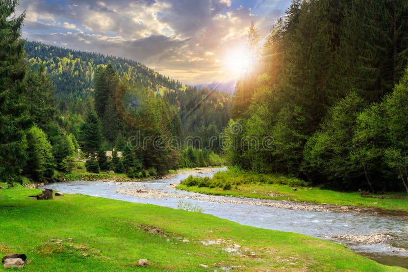 Camping place on rocky shore of mountain river near the forest at sunset. Camping place on rocky shore of mountain river near the forest at sunset