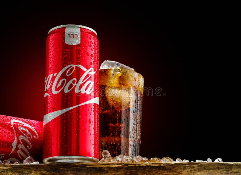 Kan och exponeringsglas av cocaen - cola med is på träbakgrund royaltyfria bilder