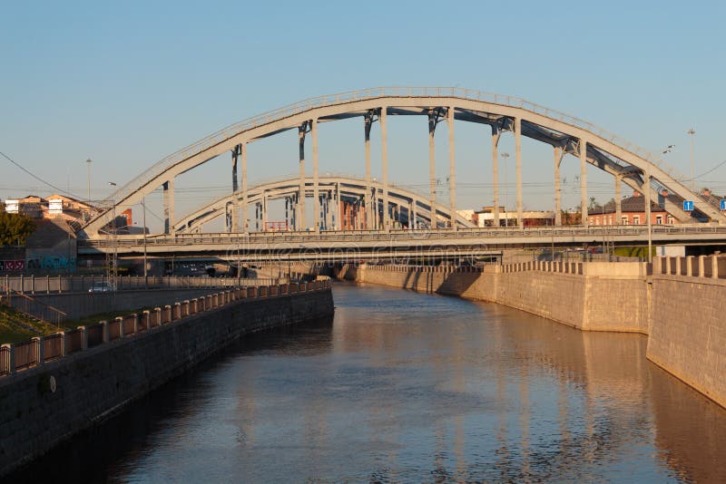Kanal med stenv?ggar och den v?lvda bron solig dag stads- landskap-bild arkivbild Kanal med stenv?ggar och den v?lvda bron solig dag stads- landskap-bild arkivbild