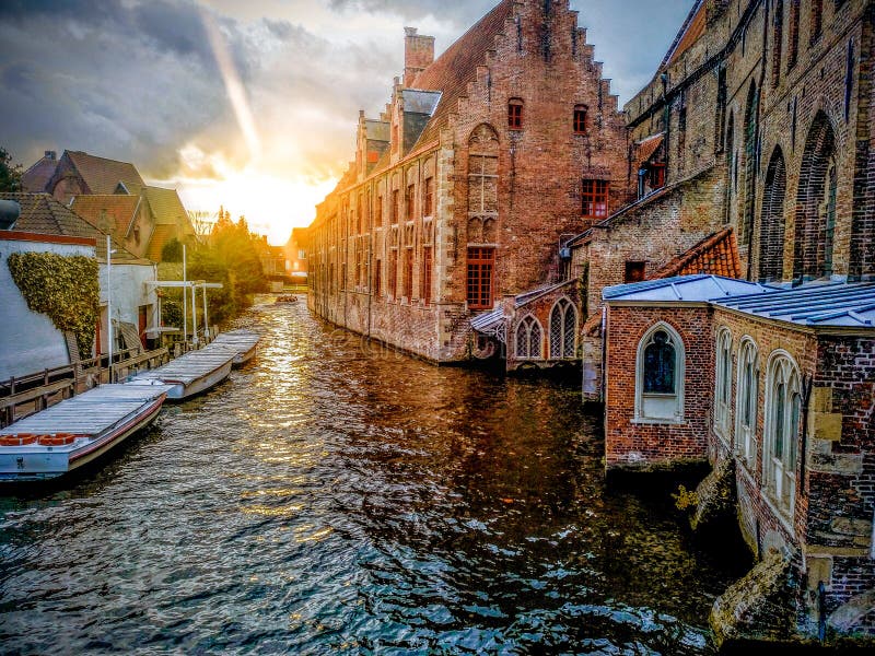 Kanaler av den medeltida staden av Brugge genom att använda de typiska fartygen över kanaler i Belgien royaltyfria bilder Kanaler av den medeltida staden av Brugge genom att använda de typiska fartygen över kanaler i Belgien royaltyfria bilder