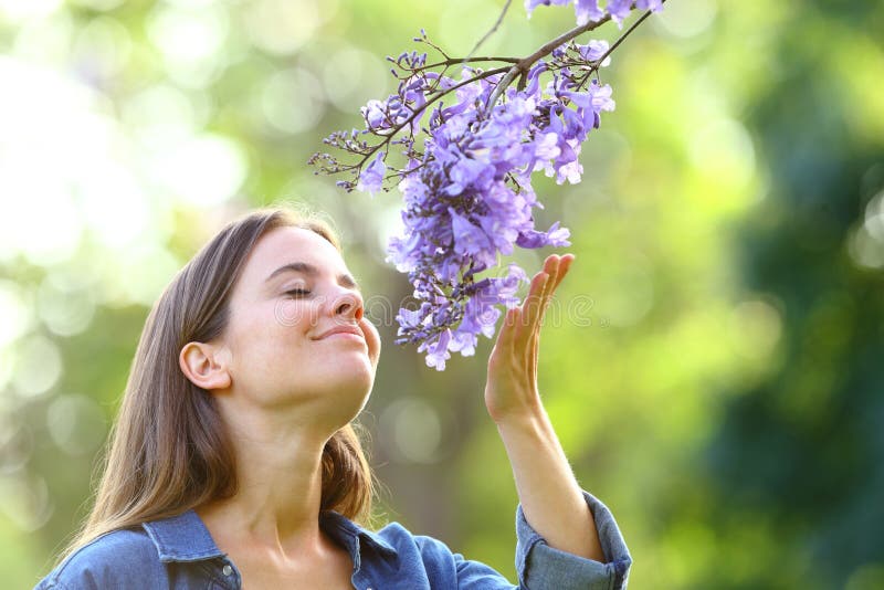 Kanarische Frau riecht in einem Park nach Blumen