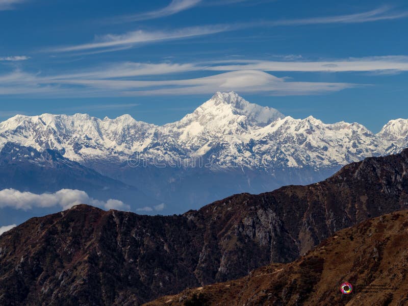 Kangchenjunga Mountain With Clouds Above. Among Green Hills That View