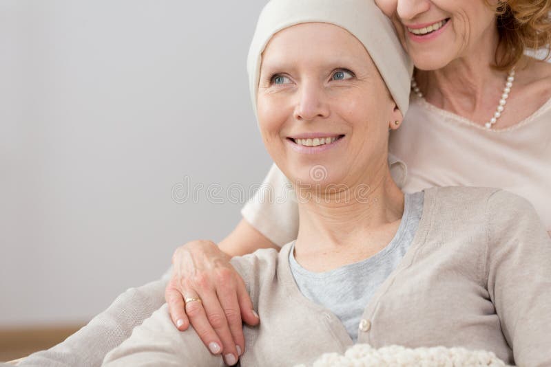 Happy cancer survivor with a headscarf, lying in an embrace of a close relative. Happy cancer survivor with a headscarf, lying in an embrace of a close relative