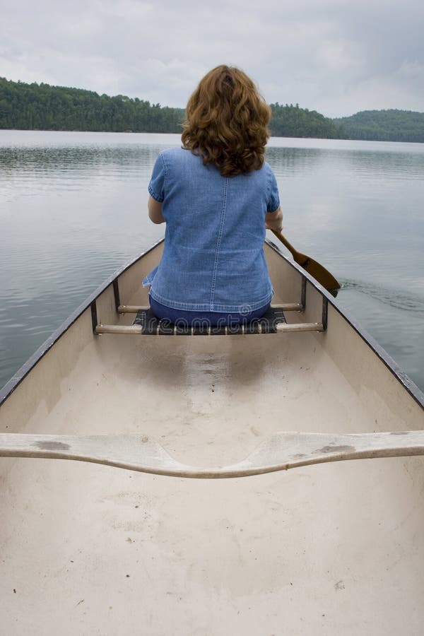 Kvinna som paddlar kanot royaltyfria bilder