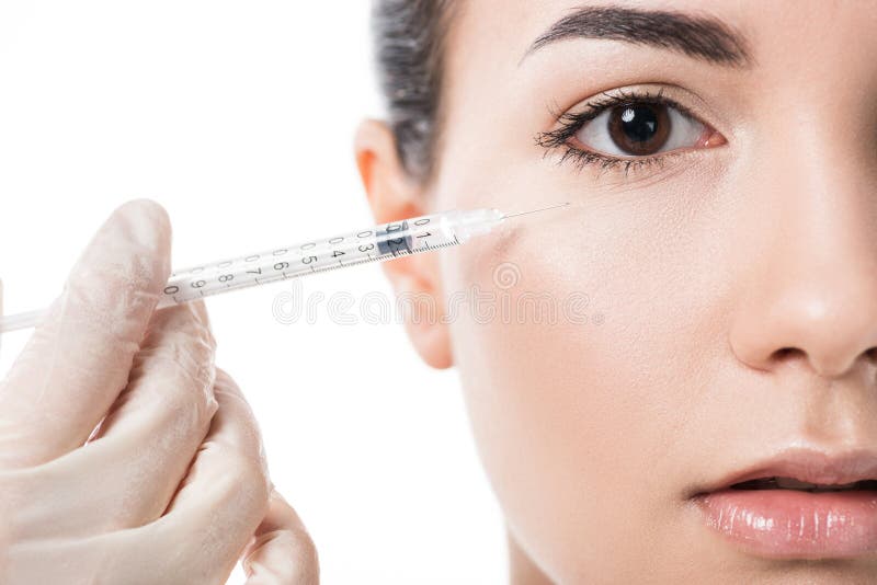 kantjusterad bild av cosmetologisten som gör skönhetinjektionen till flickan med ren hud arkivfoto kantjusterad bild av cosmetologisten som gör skönhetinjektionen till flickan med ren hud arkivfoto
