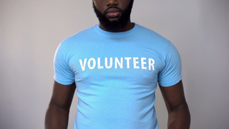 Cropped photo of black male volunteer in blue t-shirt, helping homeless people, stock photo. Cropped photo of black male volunteer in blue t-shirt, helping homeless people, stock photo
