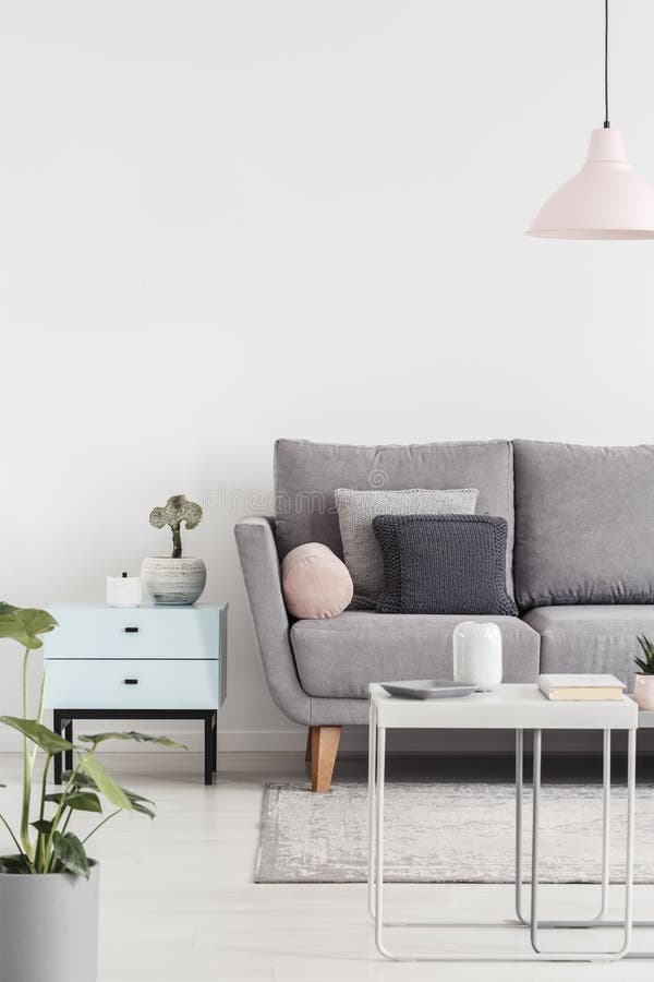 Kantjusterat foto av en soffa bredvid liten kabinett- och kaffetabell I royaltyfria foton Kantjusterat foto av en soffa bredvid liten kabinett- och kaffetabell I royaltyfria foton
