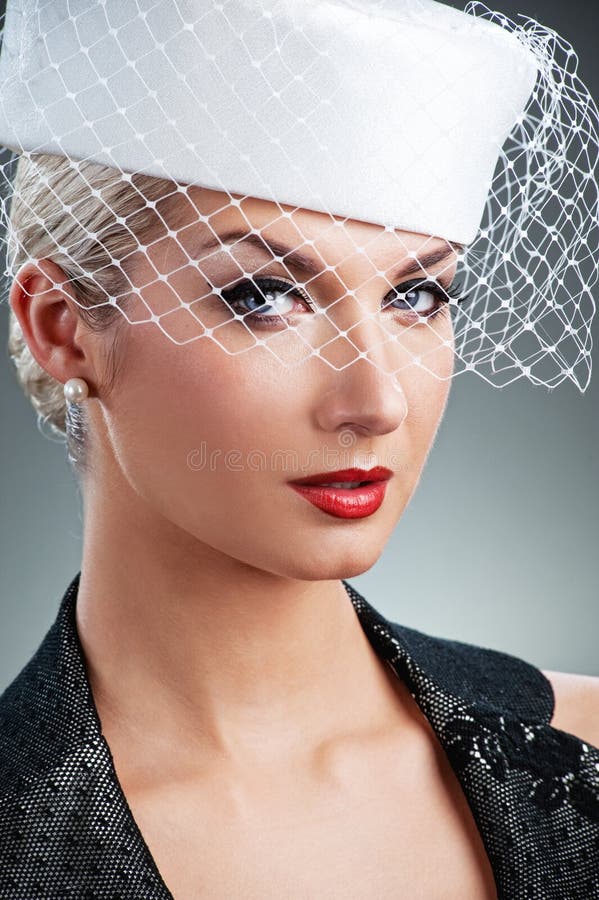 Beautiful young woman in white hat with net veil. Retro portrait. Beautiful young woman in white hat with net veil. Retro portrait