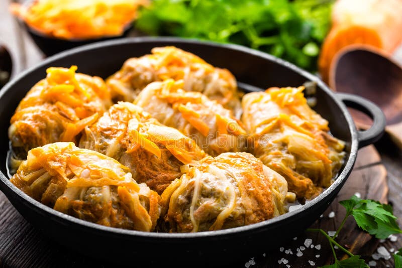 Kapust rolki stewed z mięsem i warzywami w niecce na ciemnym drewnianym tle zdjęcia royalty free Kapust rolki stewed z mięsem i warzywami w niecce na ciemnym drewnianym tle zdjęcia royalty free