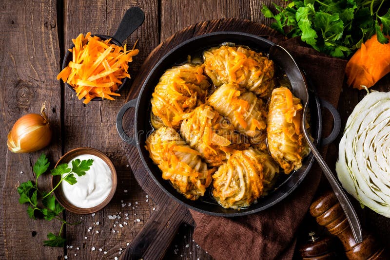 Kapust rolki stewed z mięsem i warzywami w niecce na ciemnym drewnianym tle, odgórny widok zdjęcie stock Kapust rolki stewed z mięsem i warzywami w niecce na ciemnym drewnianym tle, odgórny widok zdjęcie stock