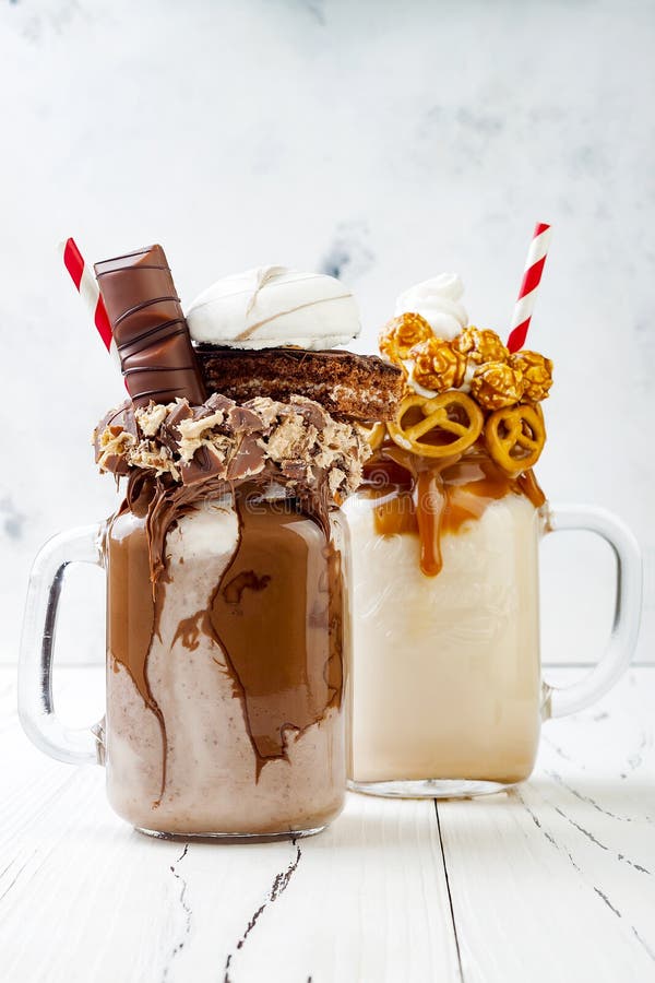 Karamel en chocolade gekke freakshake, milkshaken met brezelwafels, popcorn, heemst, roomijs en slagroom stock afbeelding Karamel en chocolade gekke freakshake, milkshaken met brezelwafels, popcorn, heemst, roomijs en slagroom stock afbeelding