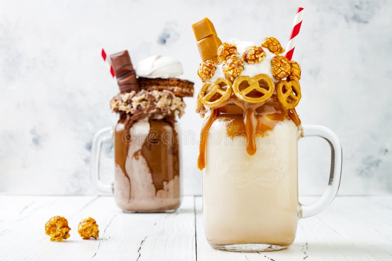 Karmel, czekoladowy szalony freakshake, milkshakes z brezel goframi, popkorn, marshmallow, lody i batożąca śmietanka, obrazy stock Karmel, czekoladowy szalony freakshake, milkshakes z brezel goframi, popkorn, marshmallow, lody i batożąca śmietanka, obrazy stock