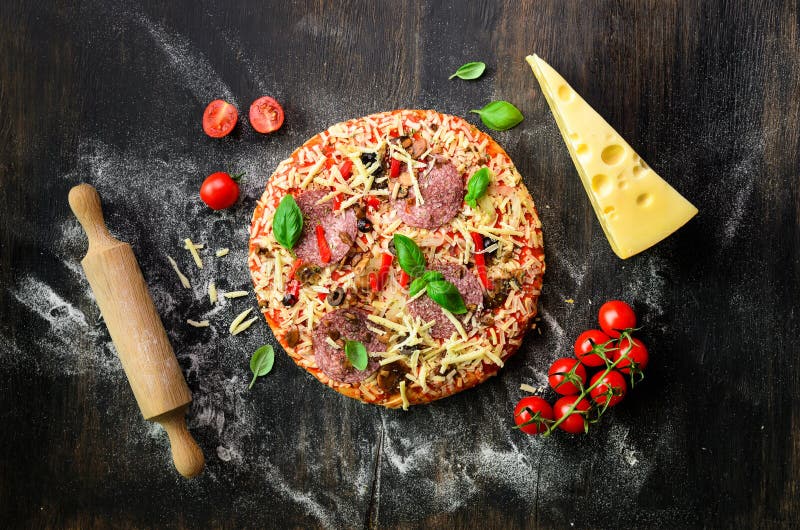 Karmowi składniki dla włoskiej pizzy, czereśniowi pomidory, mąka, ser, basil, toczna szpilka, pikantność na ciemnym tle wierzchoł fotografia royalty free Karmowi składniki dla włoskiej pizzy, czereśniowi pomidory, mąka, ser, basil, toczna szpilka, pikantność na ciemnym tle wierzchoł fotografia royalty free