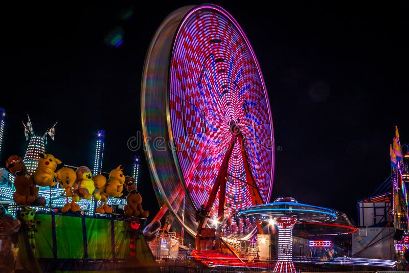 Carnival at night - rides in motion and bright blurred lights create fun entertainment for all ages. Carnival at night - rides in motion and bright blurred lights create fun entertainment for all ages