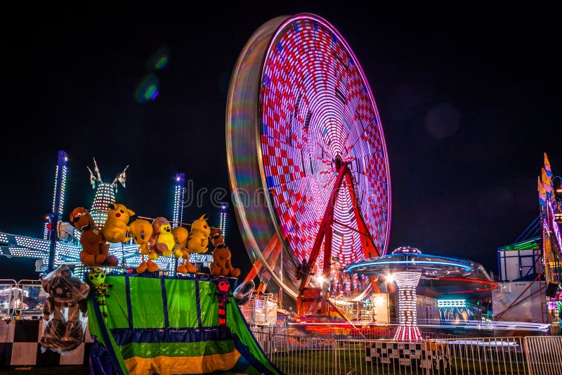 Carnival at night - rides in motion and bright blurred lights create fun entertainment for all ages. Carnival at night - rides in motion and bright blurred lights create fun entertainment for all ages