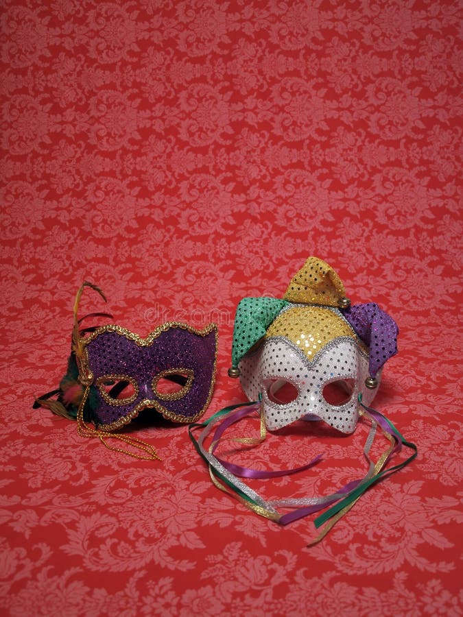 Photo of two carnival masks on red decorative fabric that includes copy and cropping space. Photo of two carnival masks on red decorative fabric that includes copy and cropping space