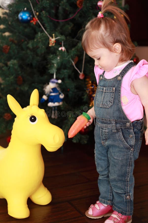 KAROTTEspielzeugesel des kleinen Mädchens speisen stockbilder