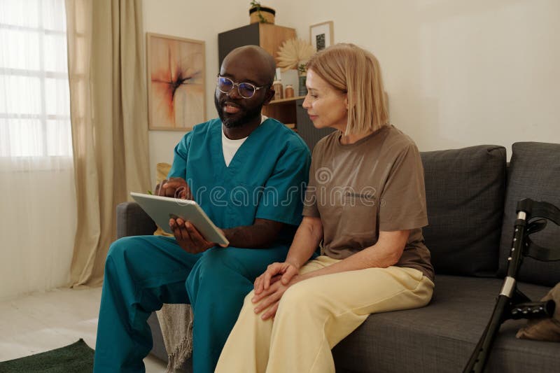 Karriere, die Tablette einer Senior Weibchen auf Couch zeigt stockbilder