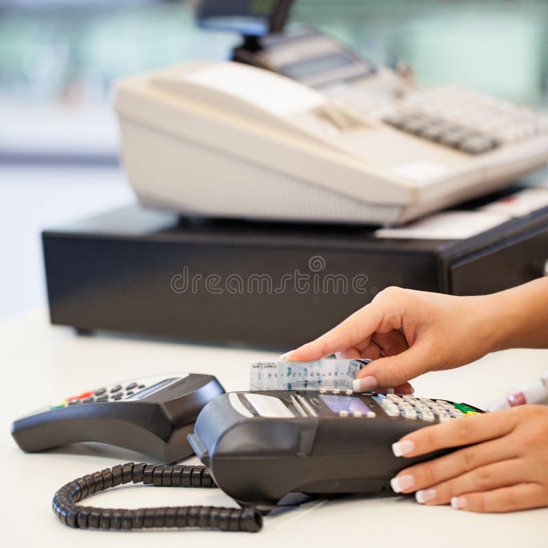 A women sliding a credit card through the card reader. Note: Fake card designed by us. A women sliding a credit card through the card reader. Note: Fake card designed by us.