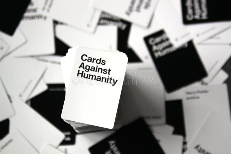 Karty Przeciw ludzkość zasięrzutnemu widokowi z rozrzuconymi kartami w tle