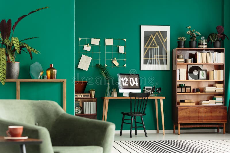 Close-up of armchair in home office interior with desk, bookshelf and green walls. Close-up of armchair in home office interior with desk, bookshelf and green walls