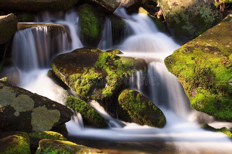 Water falls over a jumble of moss-covered boulders in Great Smoky Mountains National Park, Tennessee, USA. Water falls over a jumble of moss-covered boulders in Great Smoky Mountains National Park, Tennessee, USA.