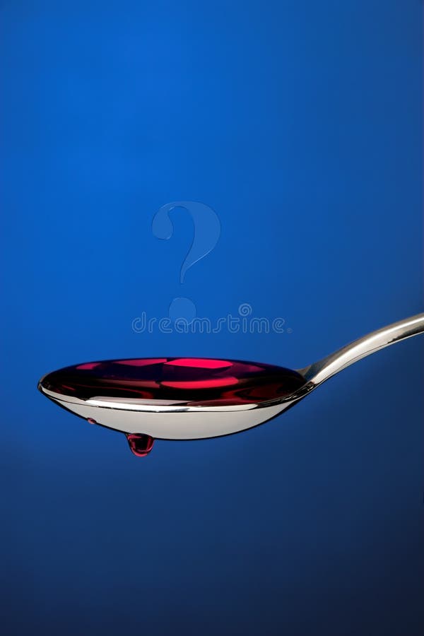 Spoon full of cough medicine over a blue backdrop. Spoon full of cough medicine over a blue backdrop