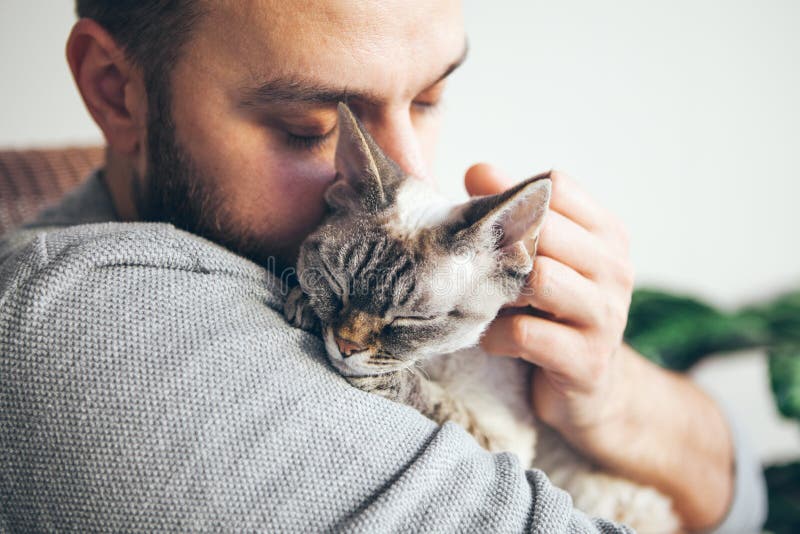 Kat en mens, portret van gelukkige kat met dichte ogen en jonge baardmens