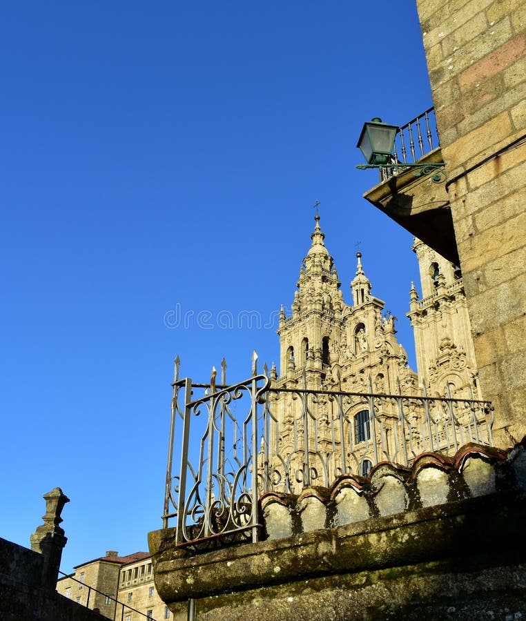 Kathedraal, barokke voorgevel met blauwe hemel, dak, oude traliewerk en straatlantaarn Santiago de Compostela, Plaza del Obradoir stock afbeeldingen Kathedraal, barokke voorgevel met blauwe hemel, dak, oude traliewerk en straatlantaarn Santiago de Compostela, Plaza del Obradoir stock afbeeldingen