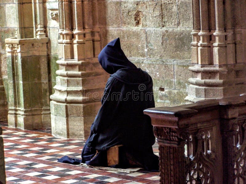 Catholic Christian Monk kneeling in humble prayer asking God for help in French Church in France Europe. Catholic Christian Monk kneeling in humble prayer asking God for help in French Church in France Europe