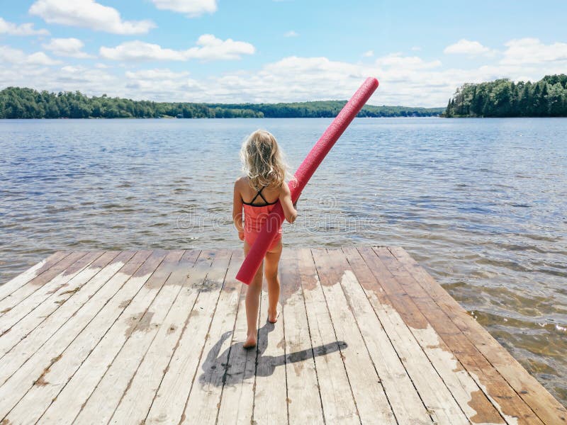 Kaukasian-Vorschulblonde-Mädchen in rosa Badeanzug auf der hölzerne Seeufer mit Pooljoodle am Sommertag stockbilder Kaukasian-Vorschulblonde-Mädchen in rosa Badeanzug auf der hölzerne Seeufer mit Pooljoodle am Sommertag stockbilder