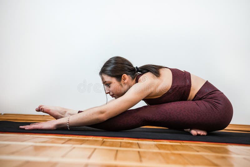 Kaukasierin, die zu Hause Yoga praktiziert stockbilder