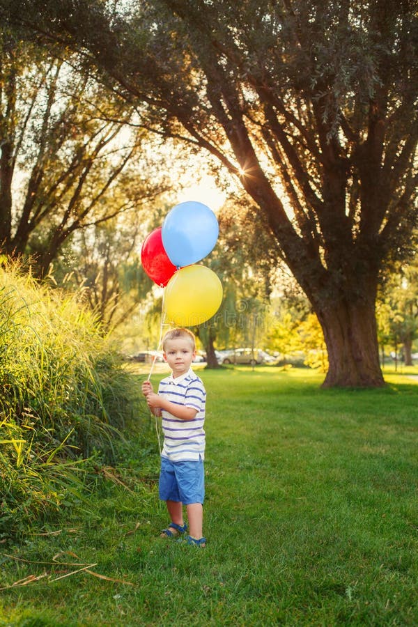 Kaukasisch jongetje peuter met kleurrijke ballonnen in park buiten stock foto Kaukasisch jongetje peuter met kleurrijke ballonnen in park buiten stock foto
