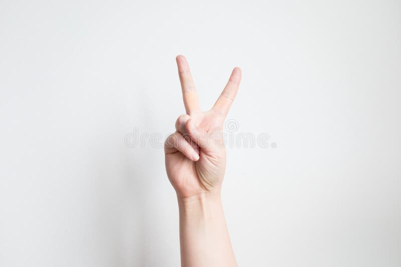 Kaukasische erwachsene Hand macht Friedenszeichen Geste vor weißem Hintergrund stockbild