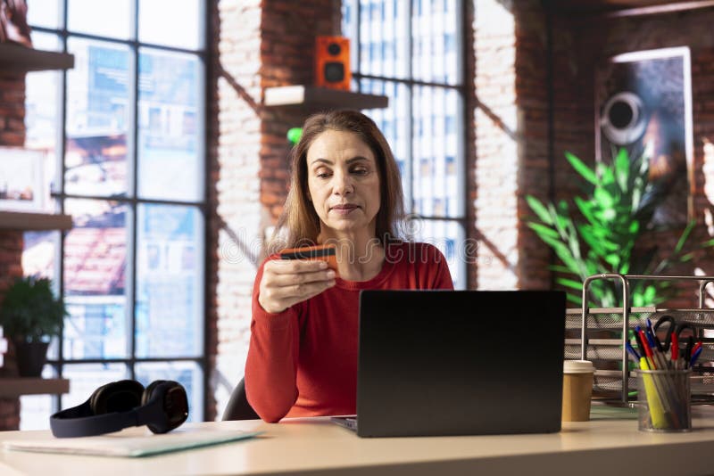Kaukasische Erwachsene zu Hause zahlen für Dinge online auf ihrem Laptop stockfotos