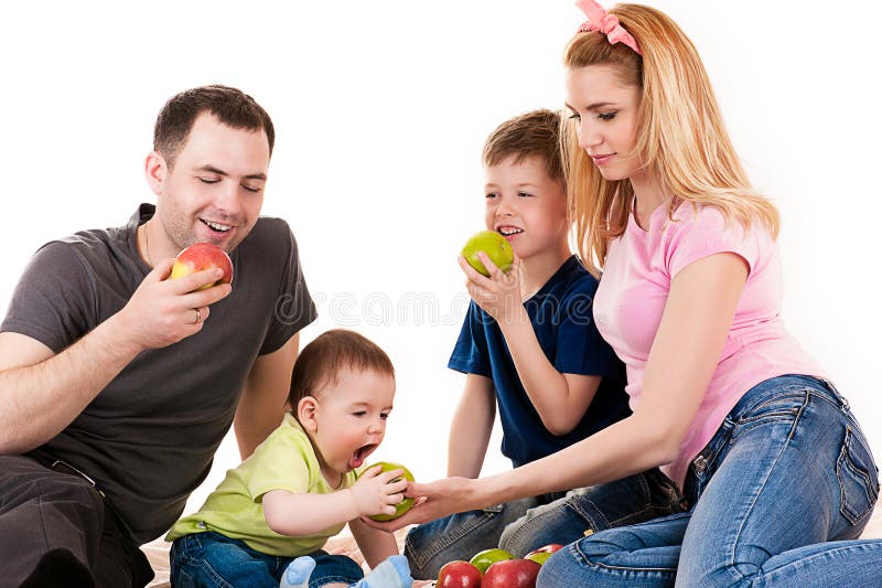 Kaukasische familie met kinderen die appelen eten stock foto Kaukasische familie met kinderen die appelen eten stock foto