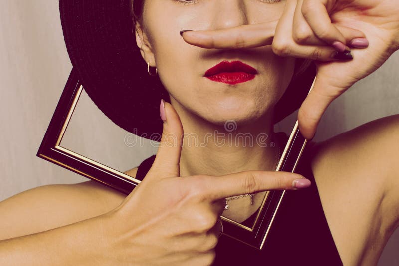 Kaukasische Frau in einem Rahmen aus einem Foto bildet einen Rahmen mit ihren Fingern Gesichter sind nicht sichtbar, nur rote Lip lizenzfreie stockfotos Kaukasische Frau in einem Rahmen aus einem Foto bildet einen Rahmen mit ihren Fingern Gesichter sind nicht sichtbar, nur rote Lip lizenzfreie stockfotos