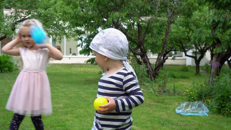 Kaukasische kinderen met moeder die ballen werpen in camera Gimbal beweging