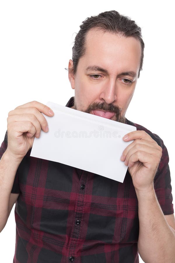 Kaukasische mens die en een witte envelop houden likken stock afbeelding Kaukasische mens die en een witte envelop houden likken stock afbeelding
