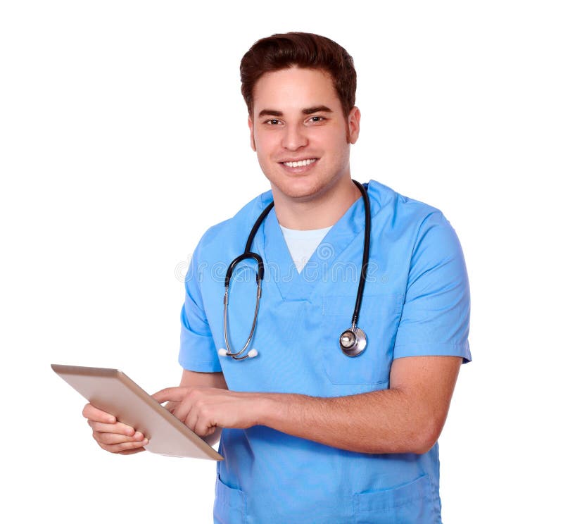 Portrait of a caucasian male nurse using his tablet pc while standing and smiling at you on isolated studio. Portrait of a caucasian male nurse using his tablet pc while standing and smiling at you on isolated studio