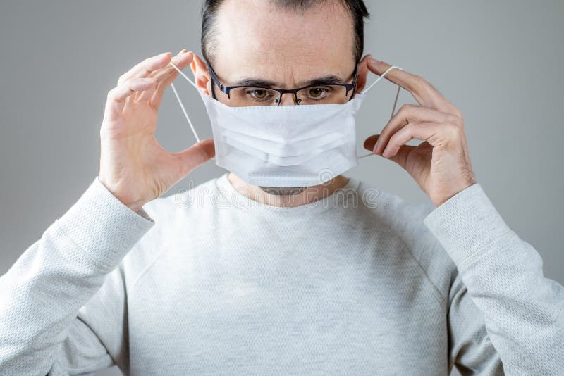 Kaukasischer Mann, der eine weiße medizinische Maske für den Schutz gegen ansteckende Krankheit Coronavirus trägt stockfotos