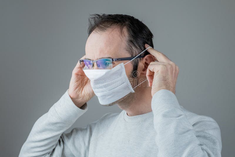 Kaukasischer Mann, der eine weiße medizinische Maske für den Schutz gegen ansteckende Krankheit Coronavirus trägt stockbilder