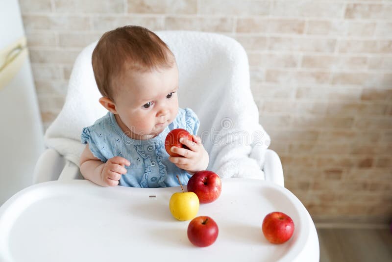 Kaukasisches Kinderkindermädchen, das im Hochstuhl isst Apfelfrucht sitzt T?glicher Lebensstil Wirklicher authentischer s??er Hau lizenzfreie stockbilder Kaukasisches Kinderkindermädchen, das im Hochstuhl isst Apfelfrucht sitzt T?glicher Lebensstil Wirklicher authentischer s??er Hau lizenzfreie stockbilder
