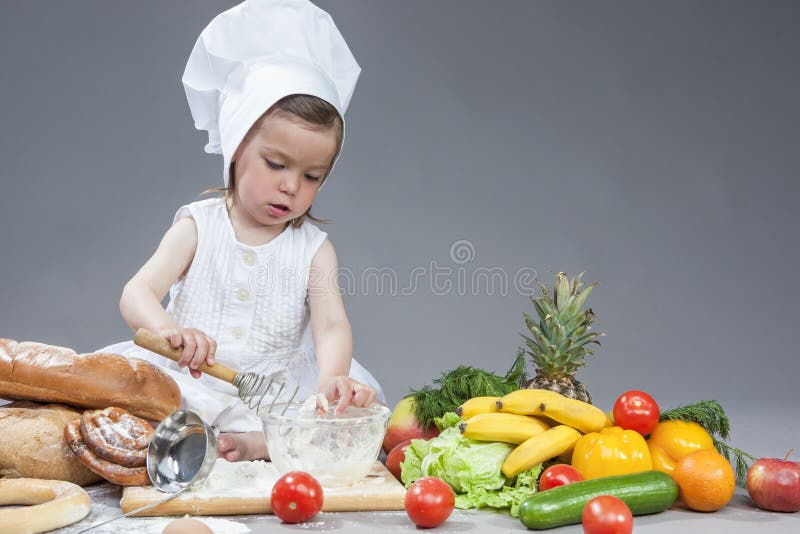 Kaukasisches Mädchen im Koch Uniform Making Food in den Küchen-Glaswaren stockfotografie Kaukasisches Mädchen im Koch Uniform Making Food in den Küchen-Glaswaren stockfotografie