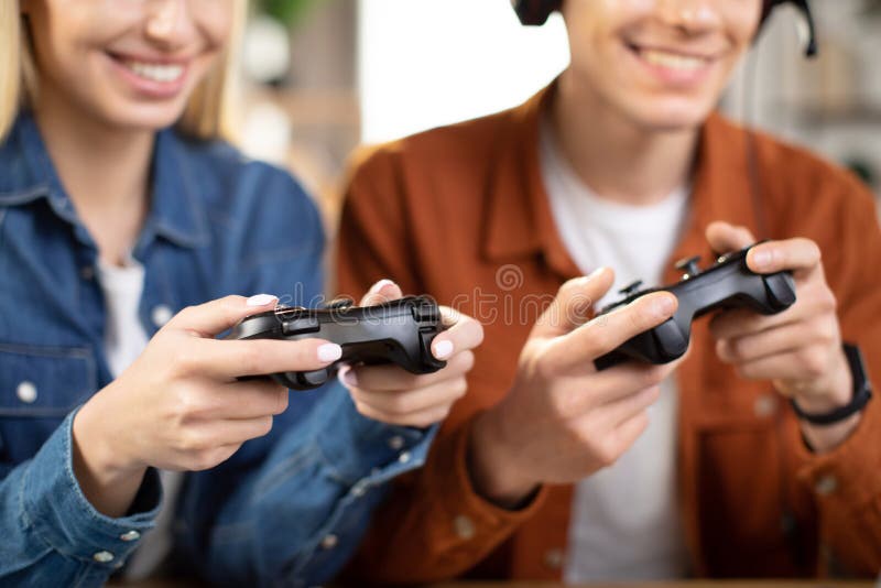 Kaukasiska familjehänder som håller joysticks och njuter av sin fritid att spela nya spel hemma royaltyfria foton