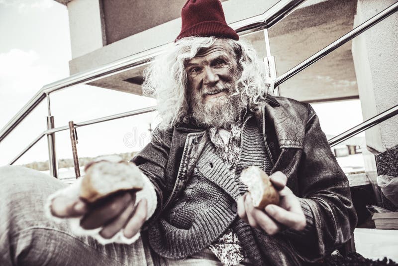 Daily feeding. Caucasian desperate almsman sitting outside and eating bun which he finding on the street nea bakery. Daily feeding. Caucasian desperate almsman sitting outside and eating bun which he finding on the street nea bakery.