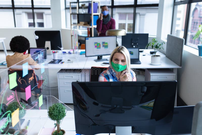 Kaukaska biznesmen ubrana w maskę w kreatywnym biurze zdjęcie stock